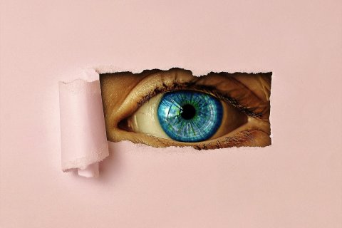 Auge blickt durch Papier