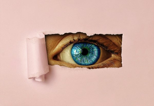 Auge blickt durch Papier